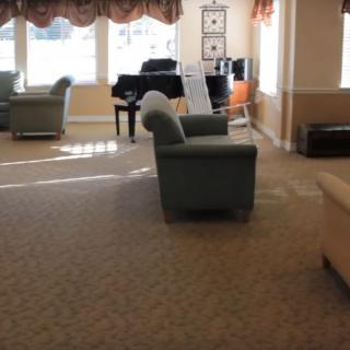 A cozy living room with a piano and comfortable seating.