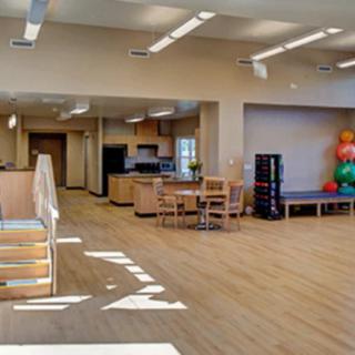 A spacious gym interior featuring exercise equipment and therapy balls.