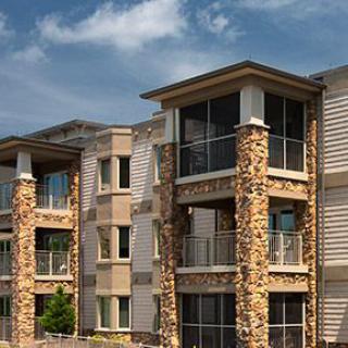 Modern apartment building with stone facade and balconies.