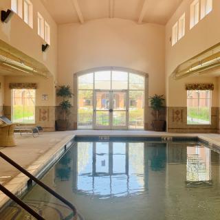A tranquil indoor pool area with large windows letting in natural sunlight.