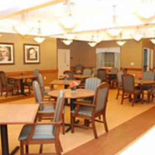 A well-lit dining room with arranged tables and chairs, featuring warm decor.