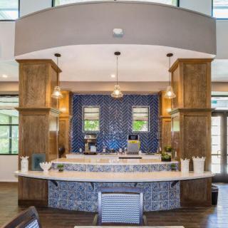A modern interior with a stylish caf counter featuring blue tiles and wooden pillars.