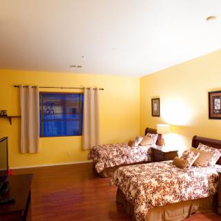 A cozy bedroom with twin beds and yellow walls.