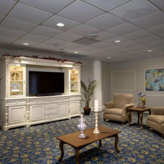 A cozy living room with elegant furnishings and a large television.