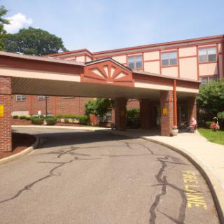 A welcoming entrance to a multi-story building with a covered drive-through area.