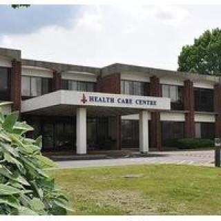 A healthcare center building with a sign 'Health Care Centre' displayed above the entrance.