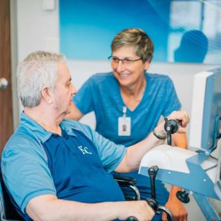 A healthcare professional assists a patient with rehabilitation exercises in a clinical setting.