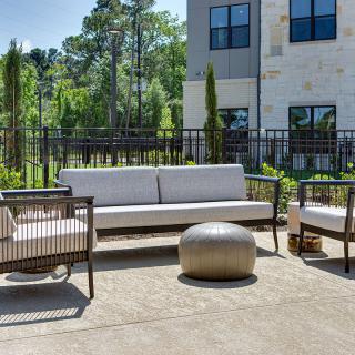A modern outdoor seating area with a sofa, chairs, and a small round table.