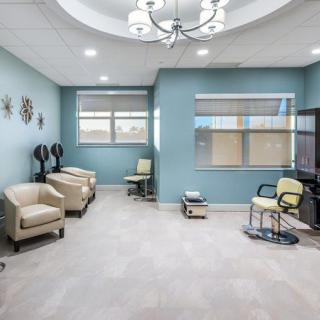 A modern and spacious office waiting room with comfortable seating and a work desk.