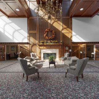 A spacious and elegant lobby with comfortable seating, a grand chandelier, and a fireplace.