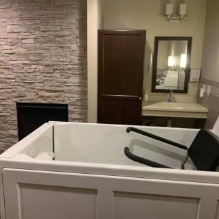 A modern bathroom featuring a bathtub, sink, and mirror with stylish design elements.