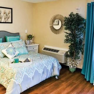 A cozy bedroom with teal accents and modern decor.