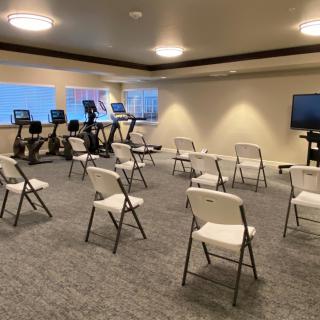 A hybrid space featuring exercise equipment and a seminar-style seating arrangement.
