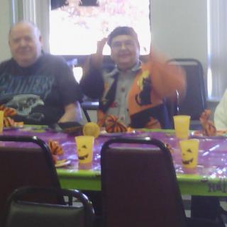A group of people sitting around a decorated table at a celebration.