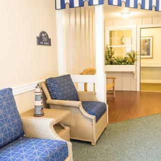 A cozy waiting area with blue upholstered chairs and decorative elements.
