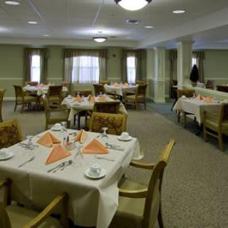 A spacious dining area with neatly arranged tables and chairs, featuring elegant table settings.