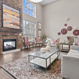 A beautifully designed modern living room featuring a cozy fireplace, elegant furniture, and abundant natural light.
