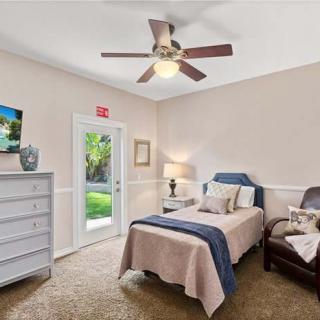 Cozy bedroom with a single bed, ceiling fan, and access to the garden.