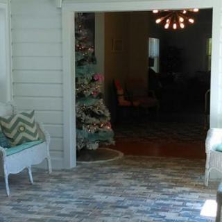 A cozy living room decorated for the holidays with a Christmas tree and modern lighting.