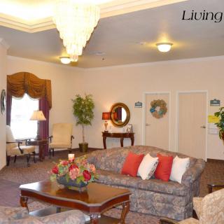 A cozy living room with a chandelier, sofa, coffee table, and decorative elements.