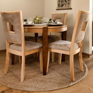 A cozy dining area featuring a round wooden table with four matching chairs on a rattan carpet.
