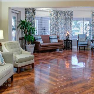 A spacious living room with hardwood floors and elegant furniture.