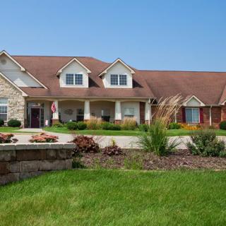 A large suburban house with a well-maintained lawn and landscaping.