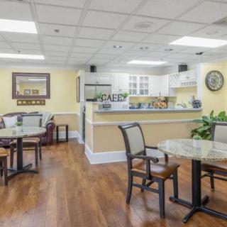 A cozy cafe interior with seating and a kitchen area.