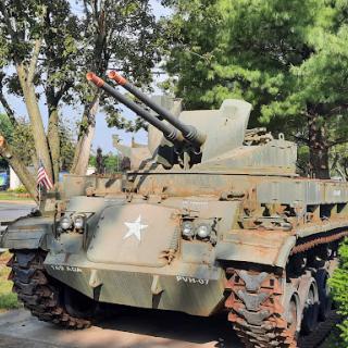 A historical military tank displayed outdoors, showcasing its artillery and rugged design.
