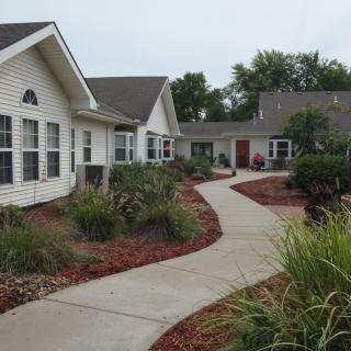 A suburban house with a landscaped garden and winding sidewalk.