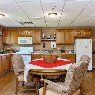 A cozy kitchen with wooden cabinets, a dining table, and modern appliances.