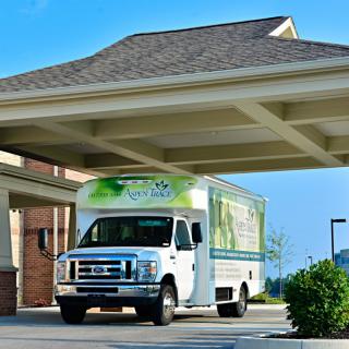 A delivery truck parked under a building's covered driveway.