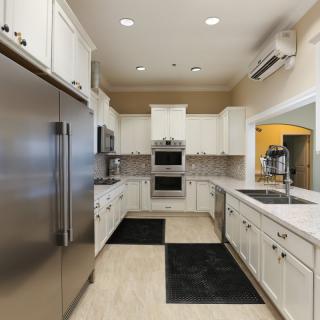 A modern kitchen with sleek appliances and white cabinetry.