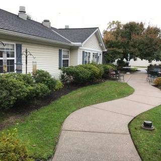 A neatly landscaped garden with a winding pathway leading to a house.