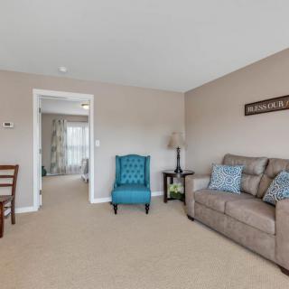 A cozy living room featuring a comfortable sofa and a vibrant armchair, with tasteful decor and a warm atmosphere.