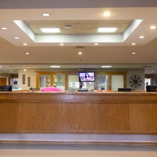 A modern reception area with a wooden desk and bright lighting.