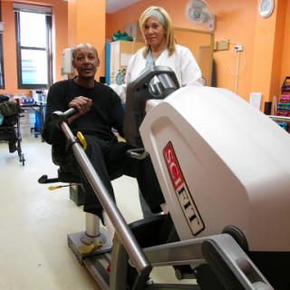 A patient engages in a therapeutic exercise session with the assistance of a healthcare professional.