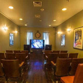 A cozy indoor theater with rows of seating facing a large screen.