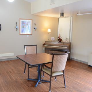A cozy dining area featuring a table and two chairs, with warm lighting and a minimalist design.