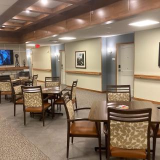 A well-lit dining area with multiple tables and chairs arranged neatly.
