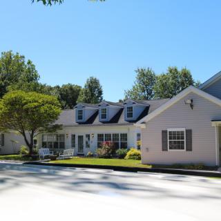 A suburban house with a well-maintained yard on a sunny day.