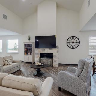 A modern living room with a fireplace, TV, and comfortable seating.