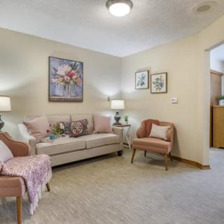 A cozy living room with a sofa, armchair, and decorative elements.