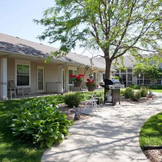 A serene garden with a pathway and benches beside a building.
