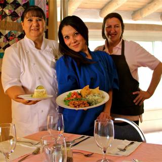 Chefs proudly display their culinary creations in a restaurant setting.