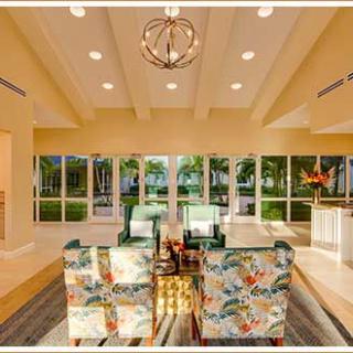 A spacious and well-lit living room with a contemporary dining area, featuring large windows and modern decor.