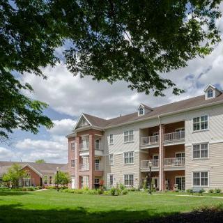 A view of a residential apartment building surrounded by greenery and trees.
