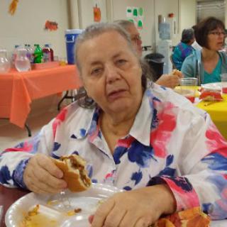 A woman enjoying a meal at a community gathering.