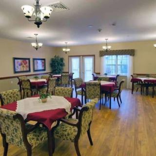 A well-furnished dining area with tables and chairs, featuring elegant decor and chandeliers.