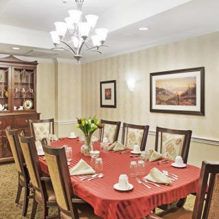 Elegant dining room with a red tablecloth, decorated settings, and classic furnishings.